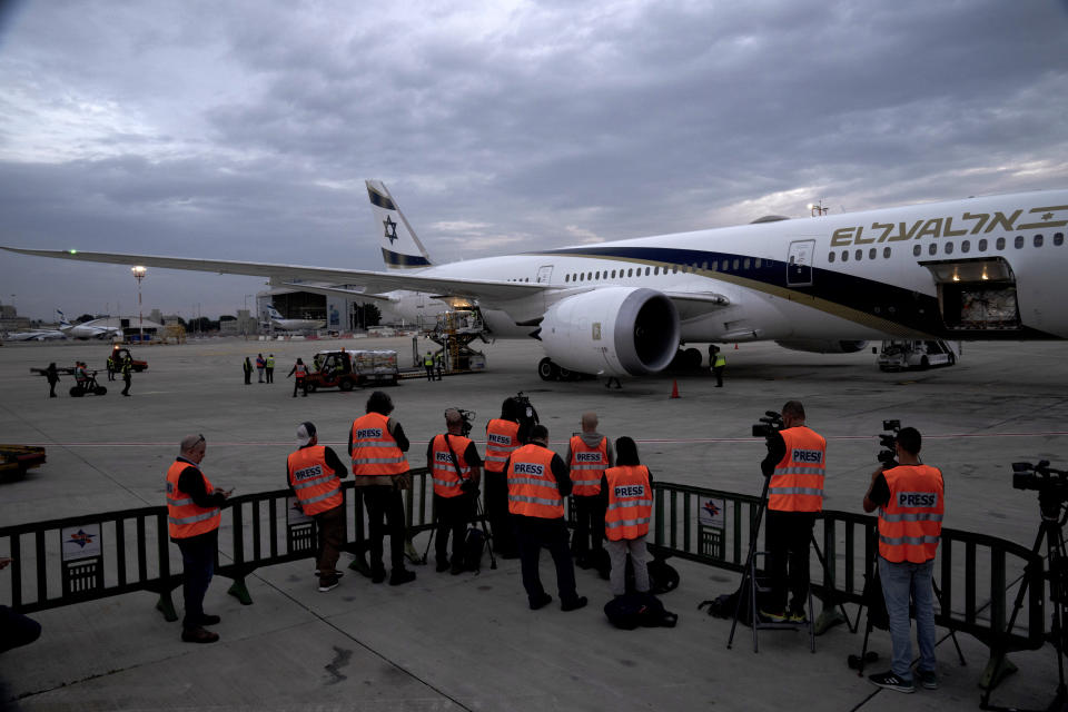 Journalists in reflective vests cover a shipment of Pfizer's antiviral COVID-19 pill, Paxlovid, on arrival at Ben Gurion International airport near Tel Aviv, Thursday, Dec. 30, 2021. (AP Photo/Maya Alleruzzo)