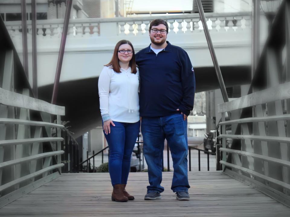 The writer poses with his fiancée on a bridge