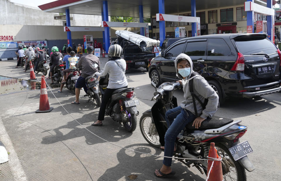 FILE - Motorists queue up to fill up their tanks after the government announced an increase in fuel prices, at a gasoline station in Jakarta, Indonesia, Sept. 3, 2022. The war, and consequent rising gas prices, forced Indonesia to reduce ballooning subsidies aimed at keeping fuel prices and some power tariffs in check. (AP Photo/Tatan Syuflana, File)
