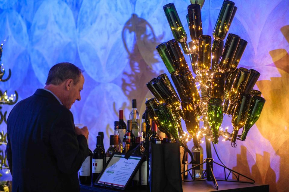 A potential bidder looks over a tree made out of wine bottles Thursday night at the 2nd annual Tidings of the Trees fundraiser event at the Panhandle-Plains Historical Museum in Canyon.