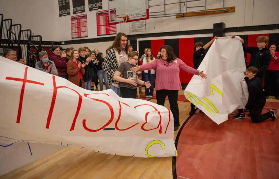 Sam Lockard and his family break through a banner during a school assembly at Thurston High School where he was introduced as the first “sparrow” for the new club.