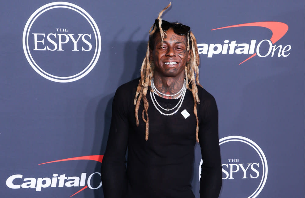 Lil Wayne is being sued by an ex-bodyguard who claims the rapper threatened him with an assault rifle and punched him in the head credit:Bang Showbiz