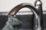 FILE - A trickle of water comes out of the faucet of Mary Gaines a resident of the Golden Keys Senior Living apartments in her kitchen in Jackson, Miss., Sept. 1, 2022. The NAACP said Tuesday, Sept. 27, that Mississippi is discriminating against Jackson’s majority-Black population by diverting badly needed federal funds for drinking water infrastructure to white communities that needed it less. (AP Photo/Steve Helber, File)