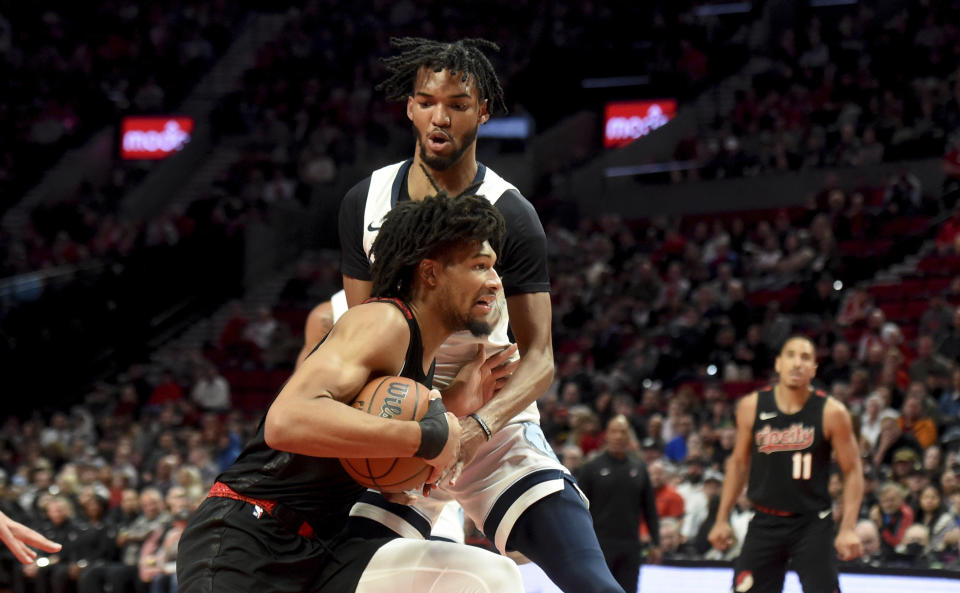 Portland Trail Blazers guard Shaedon Sharpe, bottom, drives to the basket against Memphis Grizzlies forward Ziaire Williams, top, during the first half of an NBA basketball game in Portland, Ore., Friday, Nov. 3, 2023. (AP Photo/Steve Dykes)