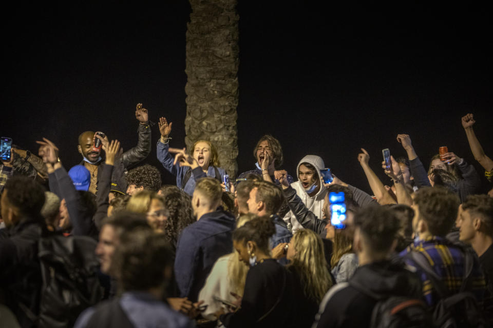 People crowded and dance on the beach in Barcelona, Spain, Sunday, May 9, 2021. Barcelona residents were euphoric as the clock stroke midnight, ending a six-month-long national state of emergency and consequently, the local curfew. Spain is relaxing overall measures to contain the coronavirus this weekend, allowing residents to travel across regions, but some regional chiefs are complaining that a patchwork of approaches will replace the six-month-long national state of emergency that ends at midnight on Saturday. (AP Photo/Emilio Morenatti)