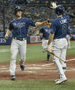 Tampa Bay Rays on-deck hitter Brandon Lowe (8) congratulates Joey Wendle, left, as he scores on a two-run double hit by Kevin Kiermaier off Miami Marlins reliever Dean Guenther during the fourth inning of a baseball game Friday, Sept. 24, 2021, in St. Petersburg, Fla. (AP Photo/Steve Nesius)