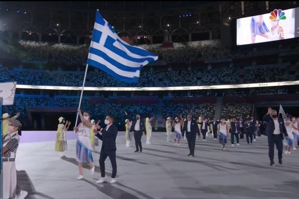 Athletes from Greece wave their country's flag to start the Parade of Nations.