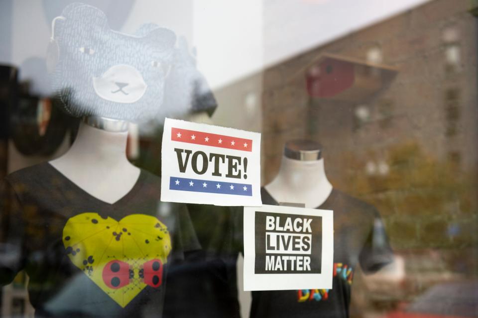 Vote and Black Lives Matter signs hang in the window of a boutique in the Over the Rhine neighborhood of Cincinnati on Sunday, Oct. 25, 2020. 