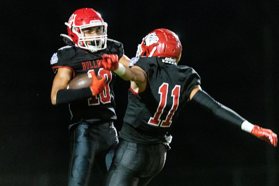 Oak Hills’ Shane Young, left, celebrates with Shea Gabriel after scoring a touchdown against Antelope Valley on Friday, Aug. 19, 2022.