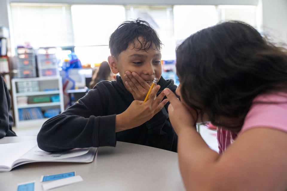 A fifth grade student explains a math answer to his classmate during a math lesson at Mount Vernon Community School, in Alexandria, Va., Wednesday, May 1, 2024. (AP Photo/Jacquelyn Martin)