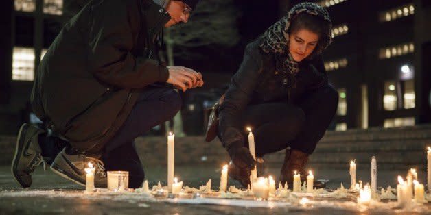 CHAPEL HILL, USA - FEBRUARY 11: Lee Elliott (L) from Chapel Hill, N.C. and Tera Schmitt (R) from Durham, N.C. relight candles in a memorial at a vigil at the University of North Carolina for Deah Shaddy Barakat, his wife Yusor Mohammad, and her sister Razan Mohammad Abu-Salha who were killed in their home the night before in Chapel Hill, North Carolina, USA, on February 11, 2015. A 46-year-old man was charged with the murder of three Muslim students who were fatally shot Tuesday at the University of North Carolinas residential complex in Chapel Hill, police said Wednesday. (Photo by Samuel Corum/Anadolu Agency/Getty Images) (Photo: )