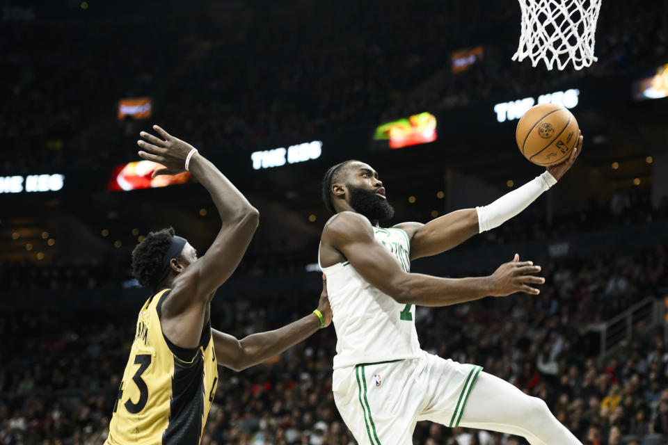 Boston Celtics guard Jaylen Brown (7) goes up for a lay up while guarded by Toronto Raptors forward Pascal Siakam during the second half of an NBA basketball game in Toronto on Friday, Nov. 17, 2023. (Christopher Katsarov/The Canadian Press via AP)