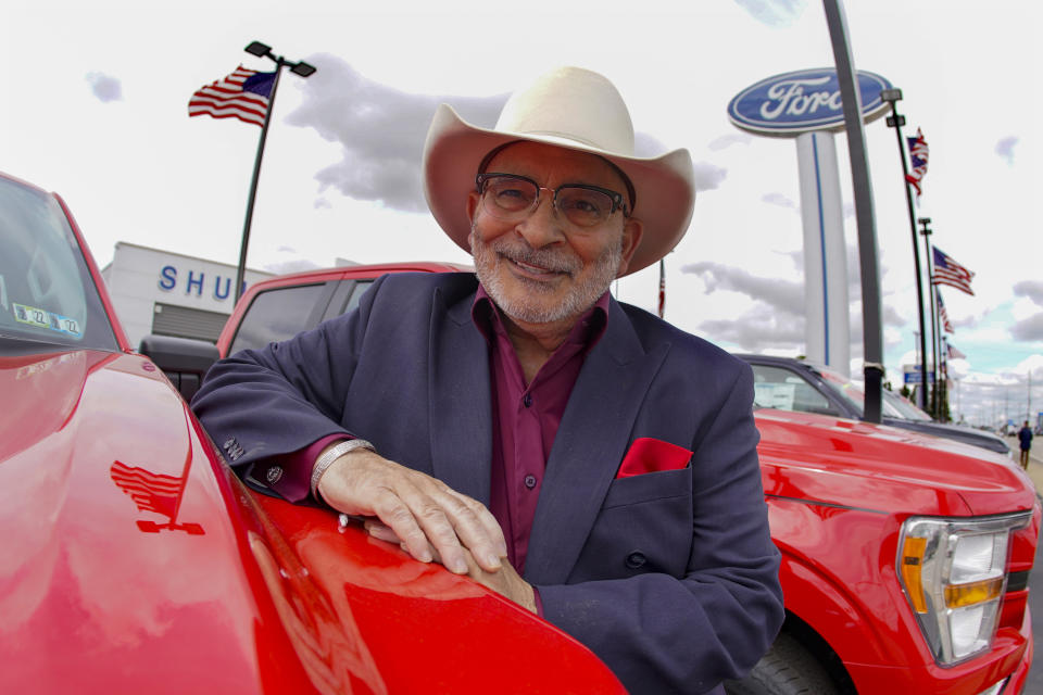 In this photo made on Thursday, May 6, 2021, Shults Ford dealership owner Richard Bazzy leans on one of the remaining Ford F150 pickups on the front line on their dealership lot in Wexford, Pa. Ford is warning that it expects to make only half the normal number of vehicles from now through June. Bazzy normally stocks 400-500 pickup trucks at his three Ford dealers, but is down around 100. He's confident that he can keep customers happy if they can order a truck and get it in four weeks, but he fears losing business to competing brands with a huge stock. (AP Photo/Keith Srakocic)