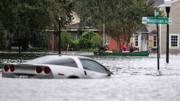 PHOTO: People paddle a canoe next to a submerged Chevy Corvette in the aftermath of Hurricane Ian in Orlando, Fla., Sept. 29, 2022.  (Jim Watson/AFP via Getty Images)