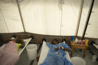 Patients with cholera symptoms lie on beds as they receive serum at a clinic run by Doctors Without Borders, in Port-au-Prince, Haiti, Friday, Nov. 11, 2022. (AP Photo/Odelyn Joseph)