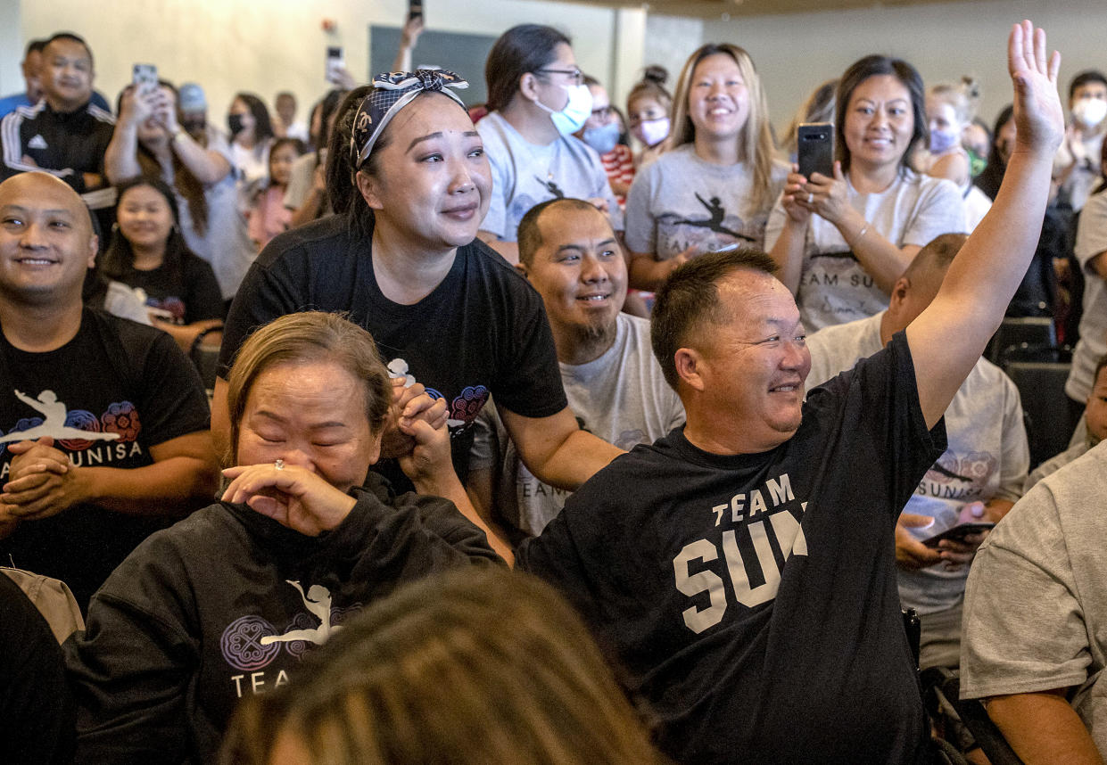 Image: Sunisa Lee's parents Yeev Thoj, left, and John Lee and other family and friends react as they watch Sunisa Lee clinch the gold medal in the women's Olympic gymnastics all-around at the Tokyo Olympics on July 29, 2021 in Oakdale, Minn. (Elizabeth Flores / Star Tribune via AP)