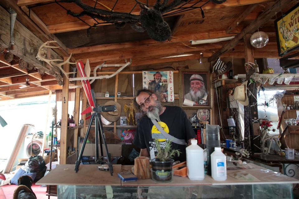 Rodney "Spyder" Wild stands in his California Ponderosa camp in Slab City, Calif., on Monday, April 5, 2021. Spyder said he is considering getting the COVID-19 vaccine but his fear of needles and needing to get two doses are factors that deter him. Spyder's Airbnb has not operated since the pandemic began.