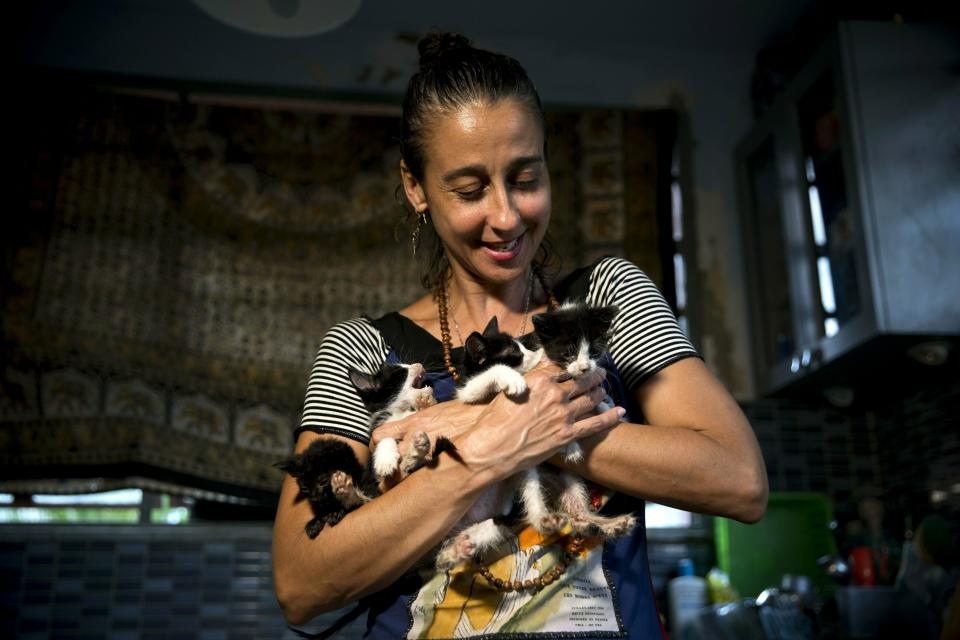 In this Thursday, April 4, 2019 photo, Grettel Montes de Oca Valdes, a professional dancer and founder of the group Cubans in Defense of Animals poses with four kittens that she has received in her house in Havana, Cuba. A group of animal-lovers will march a mile down one of Havana’s main thoroughfares Sunday waving placards calling for an end to animal cruelty in Cuba. Short, seemingly simple, the march will write a small but significant line in the history of modern Cuba. (AP Photo/Ramon Espinosa)