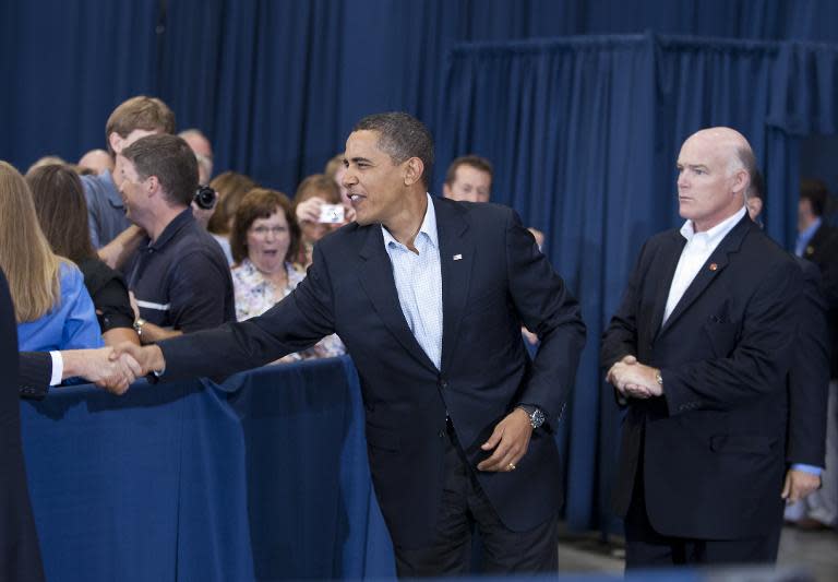 US President Barack Obama greeting attendees watched by US Secret Service agent Joseph Clancy (R) as Obama arrives for a town hall meeting