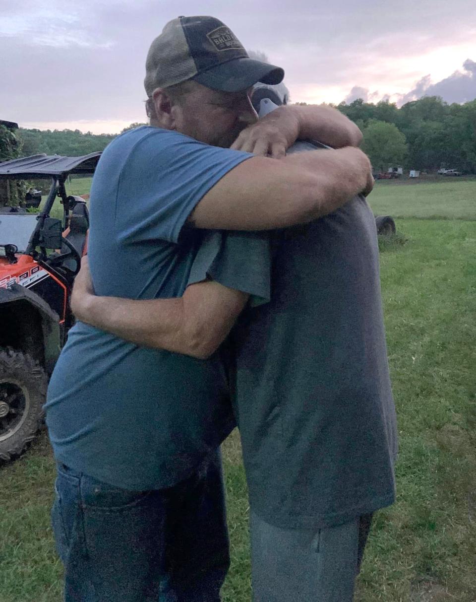 Dusty Lane of Natural Dam, Arkansas, hugs Mark Girdner, who he met for the first time after Girdner was rescued from a flooded creek nearby. Girdner misread the trail and drove off a 30-foot bluff into the water.