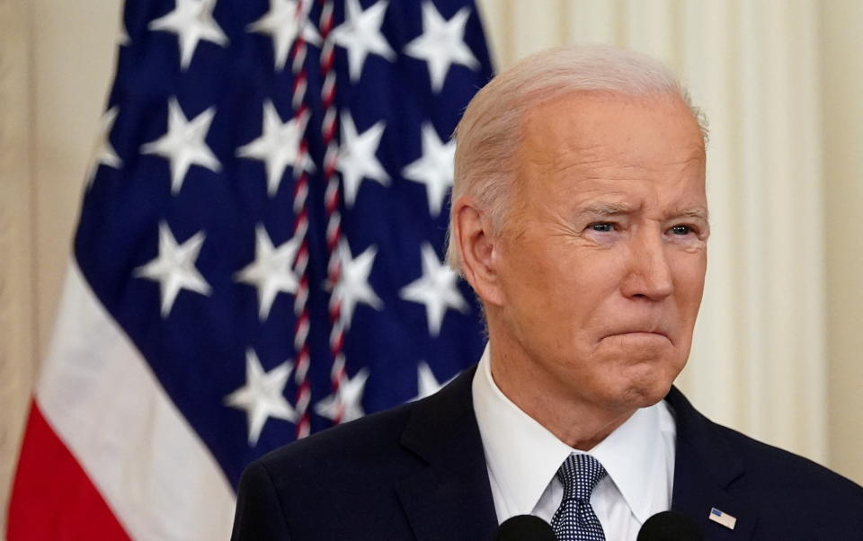 President Biden behind a microphone and in front of an American flag.