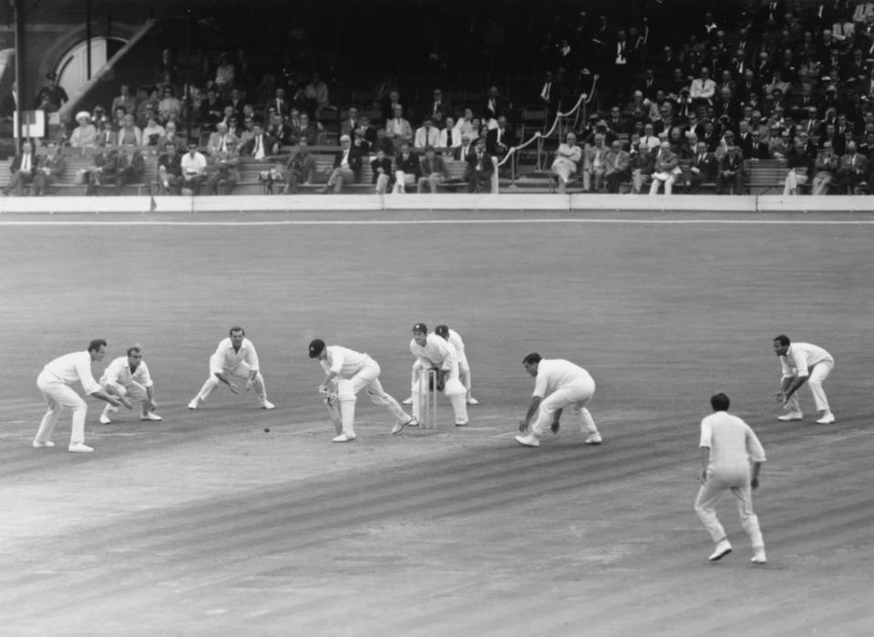 From left: Ted Dexter, John Edrich, Tom Graveney, Alan Knott, Colin Cowdrey, Colin Milburn and Basil D'Oliveira of England surround Australia’s Ashley Mallett as he plays a forward defensive at the Oval in 1968 (Getty)