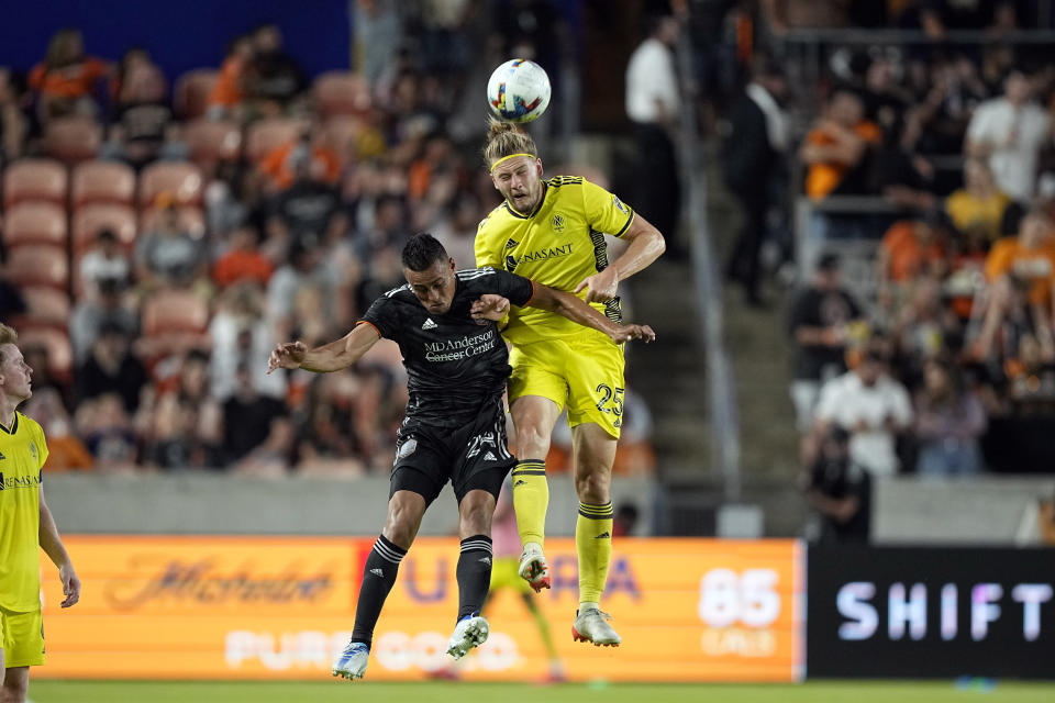 Nashville SC's Walker Zimmerman (25) and Houston Dynamo's Darwin Cerén (24) go up to head the ball during the second half of a soccer match Saturday, May 14, 2022, in Houston. (AP Photo/David J. Phillip)