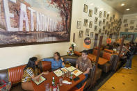 Patrons sit for lunch at tables divided by plexiglass at the Fred 62 restaurant in the Los Feliz neighborhood of Los Angeles, Monday, Nov. 29, 2021. Enforcement began Monday in Los Angeles for one of the strictest vaccine mandates in the country, a sweeping measure that requires proof of COVID-19 shots for everyone entering a wide variety of businesses from restaurants to theaters and gyms to nail and hair salons. (AP Photo/Damian Dovarganes)