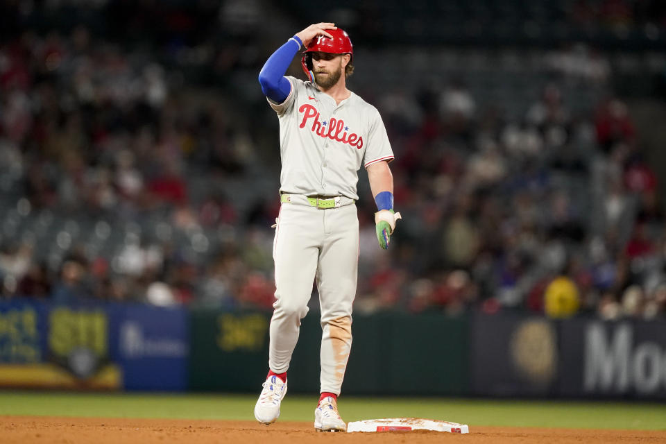 Philadelphia Phillies' Bryce Harper adjusts his helmet while on second base during the seventh inning of a baseball game against the Los Angeles Angels, Monday, April 29, 2024, in Anaheim, Calif. (AP Photo/Ryan Sun)