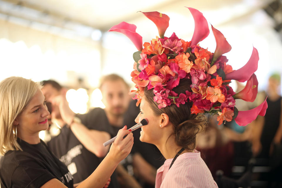 <p>So etwas sehen die Visagisten auch nicht alle Tage: Ein Model trägt im Backstage-Bereich einen großen Kopfschmuck aus Blumen, damit geht es später auf den Laufsteg für die Show des deutschen Labels Maison Common. (Bild: Joern Pollex/Getty Images) </p>