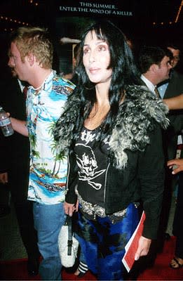 Cher looks up, up in the sky as the dude behind her looks for munchies