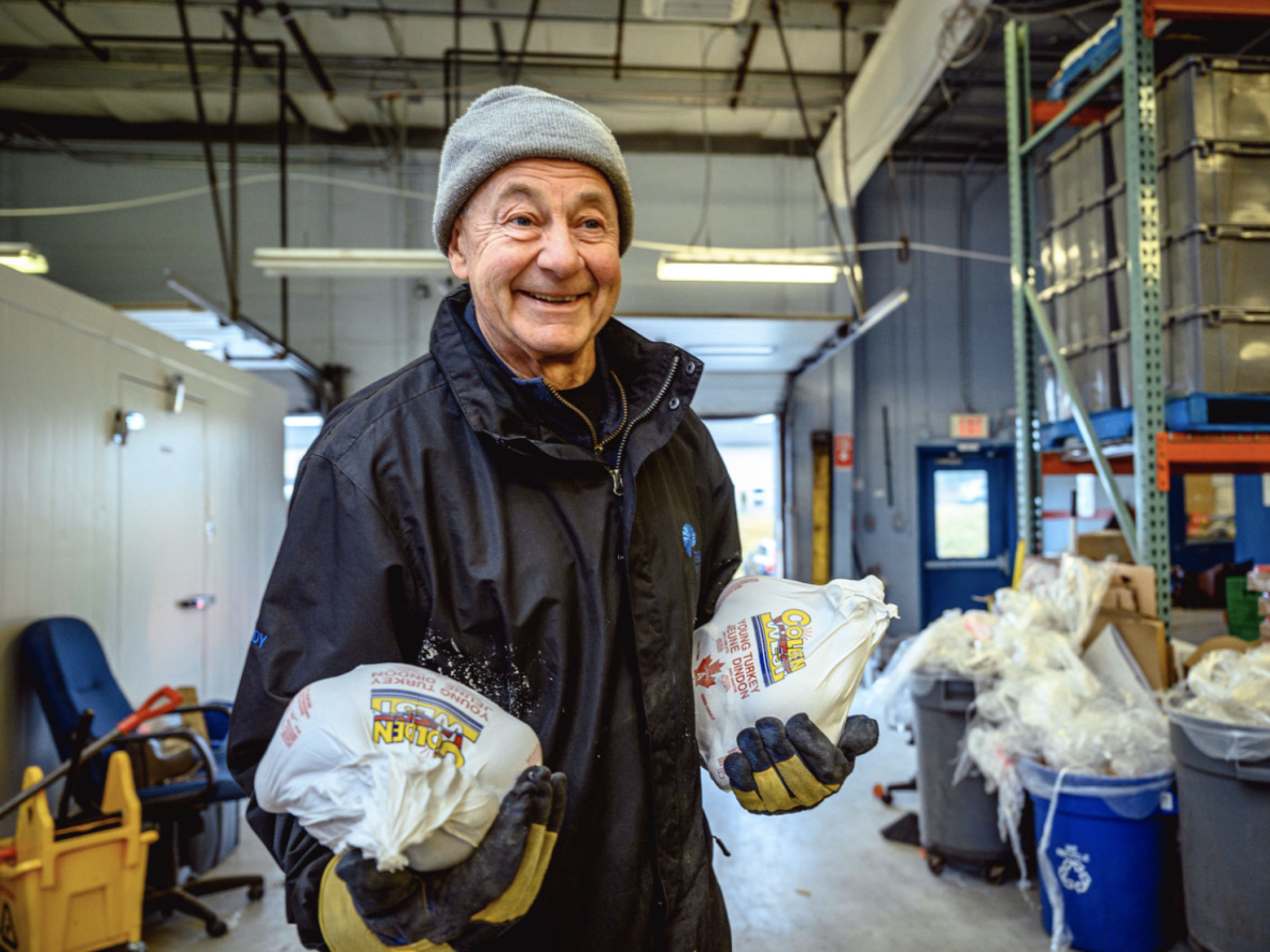 Volunteer Randy Mercer has his hands full of turkeys at the Community Food Sharing Association warehouse in St. John's. (Ritche Perez - image credit)