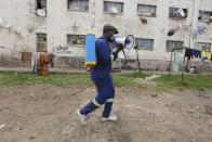A man moves around offering fumigation services in a poor neighborhood to curb the spread of COVID-19 in Harare, Zimbabwe, Monday, Nov, 29, 2021. The emergence of the new omicron variant and the world’s desperate and likely futile attempts to keep it at bay are reminders of what scientists have warned for months: The coronavirus will thrive as long as vast parts of the world lack vaccines. (AP Photo/Tsvangirayi Mukwazhi)