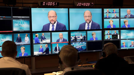 German Chancellor Angela Merkel of the Christian Democratic Union (CDU) and her challenger, Germany's Social Democratic Party SPD candidate for chancellor Martin Schulz are seen on screens at a TV studio during a debate in Berlin, Germany, September 3, 2017. Herby Sachs/WDR/Handout via REUTERS