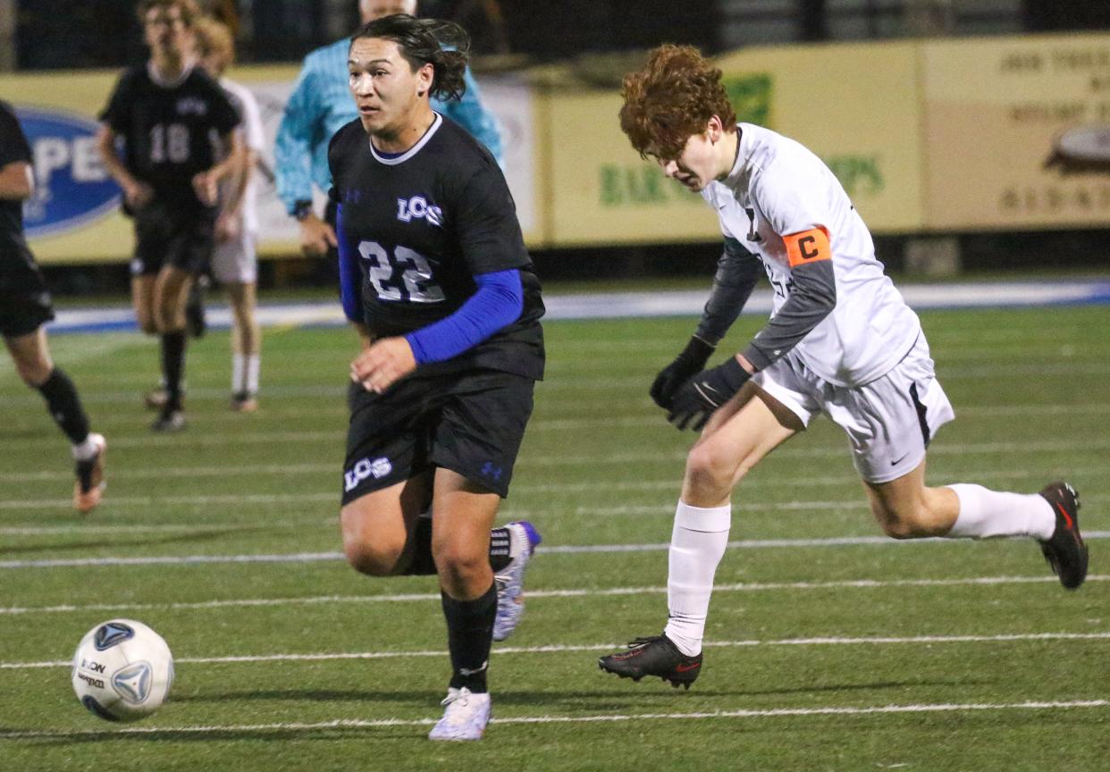 Lakeland Christian's Adrian Villanueva races toward the goal as Lakeland's Cullen Wyatt gives chase on Friday night at Viking Stadium.