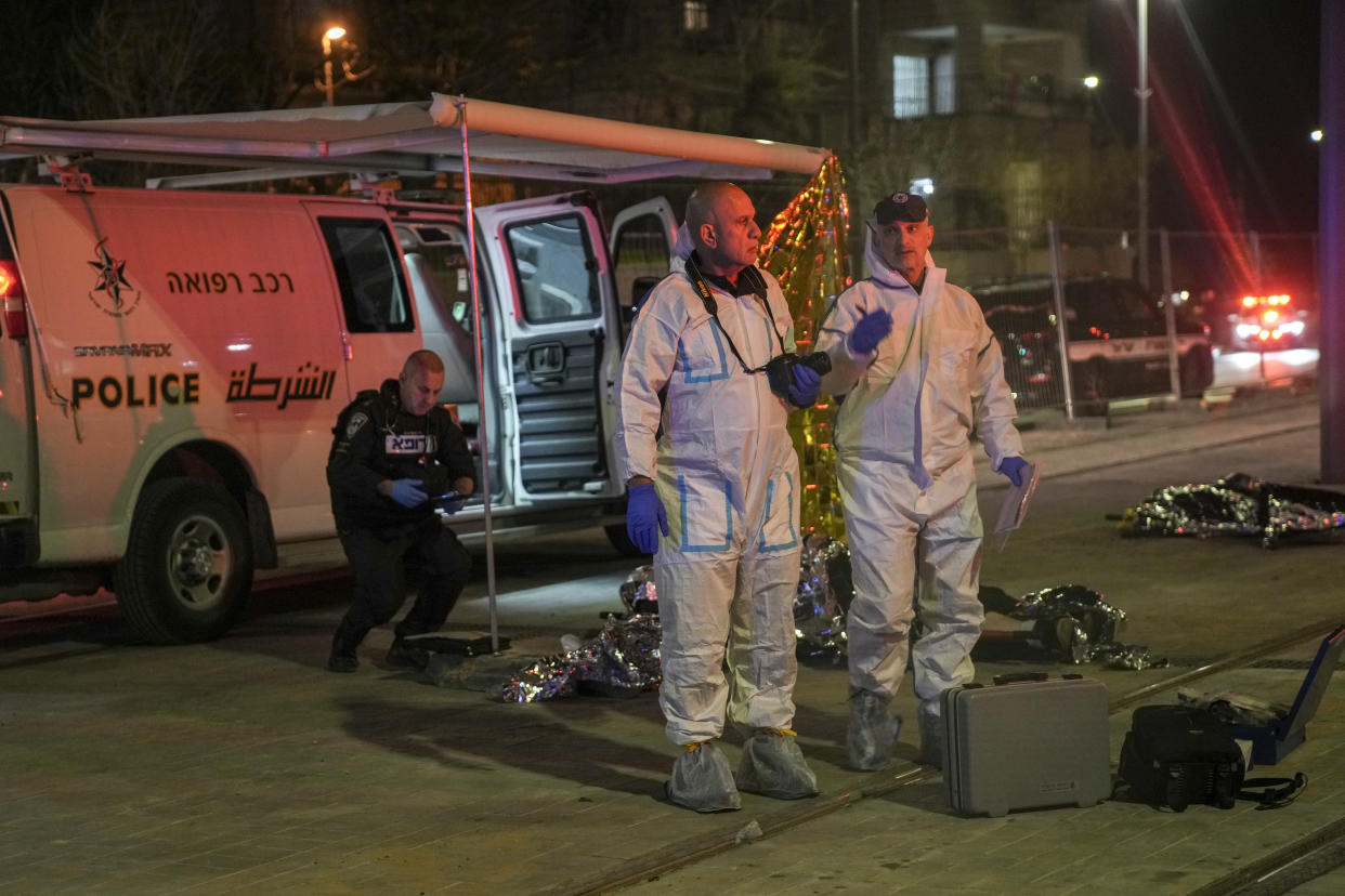 Forensic work by victims of a shooting attack near a synagogue in Jerusalem, Friday, Jan. 27, 2023. A Palestinian gunman opened fire outside an east Jerusalem synagogue Friday night, killing five people and wounding five others in one of the deadliest attacks on Israelis in years, medical officials said. The attack was halted when the gunman was shot by police. (AP Photo/Mahmoud Illean)