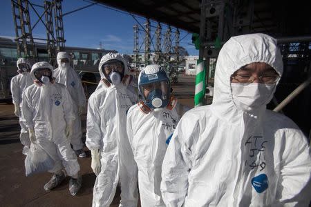 Workers in protective suits and masks wait to enter the emergency operation center at the crippled Fukushima Daiichi nuclear power plant in Fukushima prefecture in this November 12, 2011 file photo. REUTERS/David Guttenfelder/Pool
