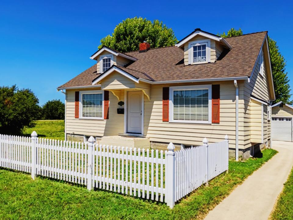 small house with partial picket fence in the front yard