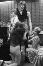 <p>David Bowie, preparing for a performance backstage, circa 1973. He is being dressed in an extravagant costume by his wife Angie Bowie (right) and an assistant.</p>