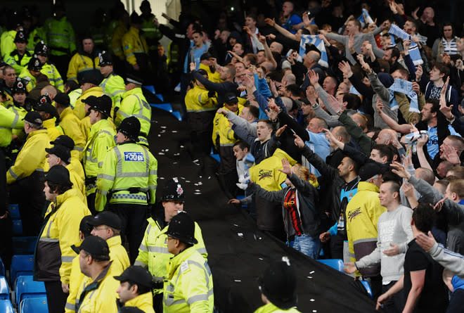 Manchester City fans (R) gesture towards Manchester United fans after their team won 1-0 during their English Premier League football match at The Etihad stadium in Manchester, north-west England on April 30, 2012. AFP PHOTO/PAUL ELLIS RESTRICTED TO EDITORIAL USE. No use with unauthorized audio, video, data, fixture lists, club/league logos or “live” services. Online in-match use limited to 45 images, no video emulation. No use in betting, games or single club/league/player publications.PAUL ELLIS/AFP/GettyImages