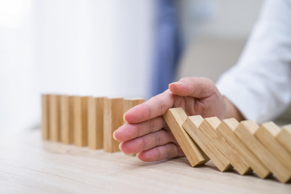 Stopping the domino effect concept for business solution, strategy and successful intervention. Photo: Getty