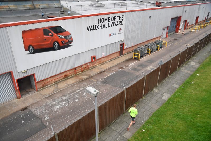 A man runs past the perimeter of Vauxhall's Luton plant in Luton