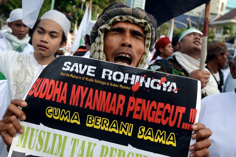 A protester belonging to the hardline Islamic Defenders Front (FPI) holds a placard calling to "stop the massacre of Muslim Rohingya and Myanmar Buddhists cowards" during a rally in Jakarta, Indonesia