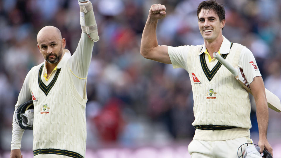 Nathan Lyon and Pat Cummins pump their fists after winning the first Ashes Test.