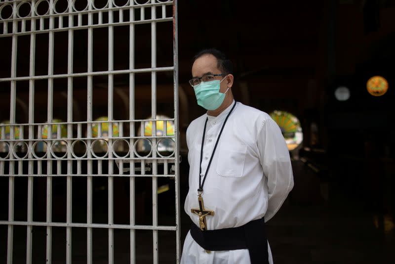 The Wider Image: Hazmat suits and holy water: two priests bring faith to Philippines lockdown