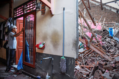 A man looks at debris from his partially collapsed home following a strong earthquake in Lendang Bajur Hamlet, Lombok island, Indonesia August 6, 2018 in this photo taken by Antara Foto. Antara Foto/Ahmad Subaidi/ via REUTERS