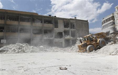 A man operates an excavator at Ain Jalout school that was hit by what activists said was an airstrike by forces loyal to Syria's President Bashar al-Assad in Aleppo's al-Ansari al-Sharqi neighbourhood April 30, 2014. REUTERS/Jalal Al-Mamo