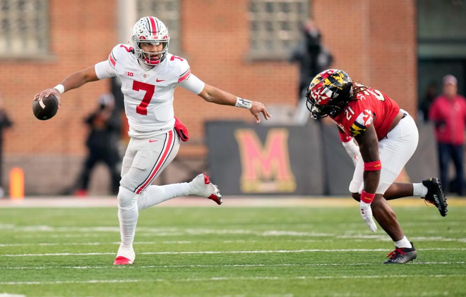 Nov 19, 2022; College Park, MD, USA; Ohio State Buckeyes quarterback C.J. Stroud (7) gets away from Maryland Terrapins linebacker Gereme Spraggins (21) before throwing the ball in the second quarter of their Big Ten game at SECU Stadium. 