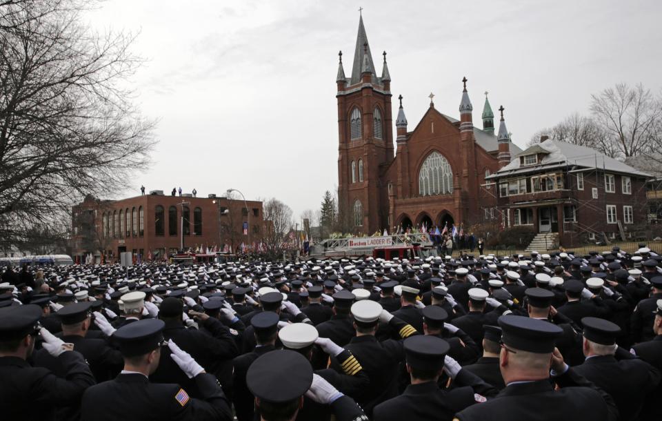 Firefighters salute as the casket of Boston Fire Lt. Edward Walsh is lowered from Engine 33 as it arrives outside the Church of Saint Patrick in Watertown, Mass., Wednesday, April 2, 2014. Walsh and Boston Firefighter Michael Kennedy died after being trapped while battling a fire in Boston. (AP Photo/Charles Krupa)