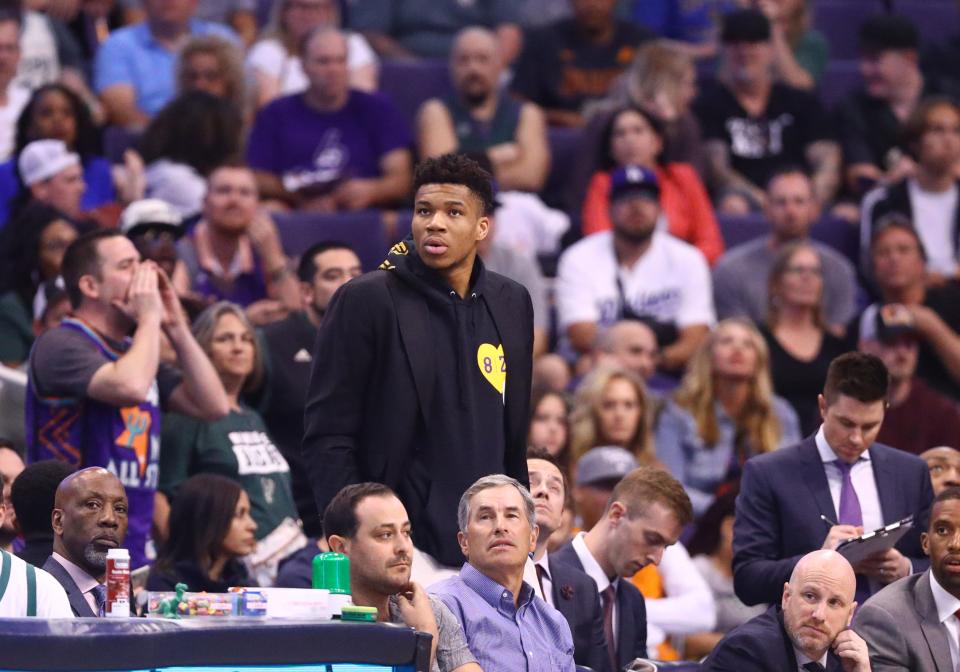 Giannis Antetokounmpo is forced to watch the Bucks' game against the Suns from the sideline after he suffered a minor joint capsule sprain in his left knee Friday night.